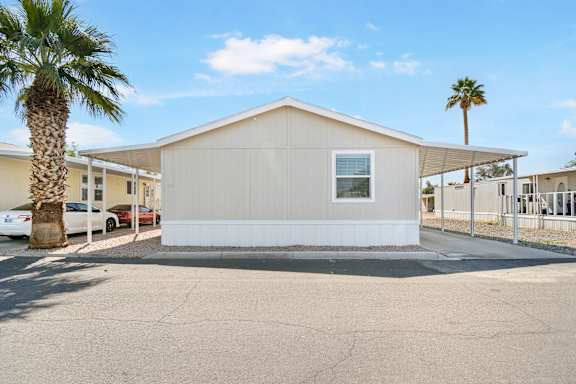 A small white house with a palm tree in front of it.
