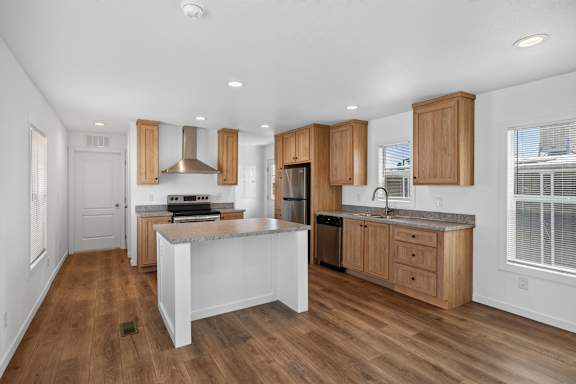 A kitchen with wooden cabinets and a white island.