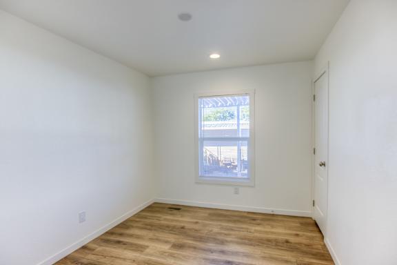 A room with a window and wooden flooring.