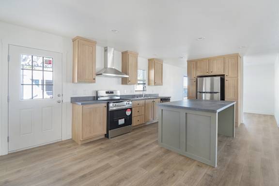 A kitchen with wooden cabinets and a grey island.
