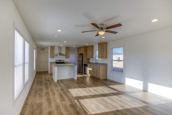 A spacious room with a ceiling fan and wooden flooring.
