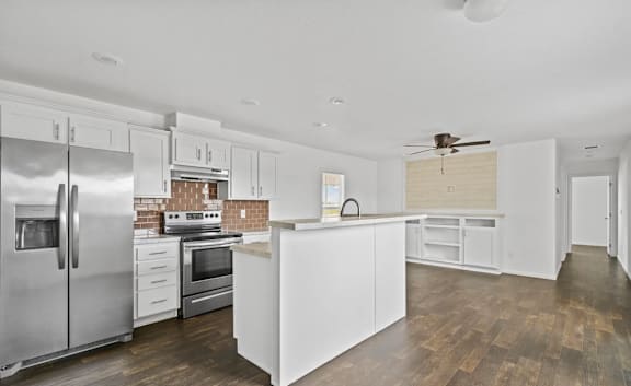 A modern kitchen with white cabinets and stainless steel appliances.
