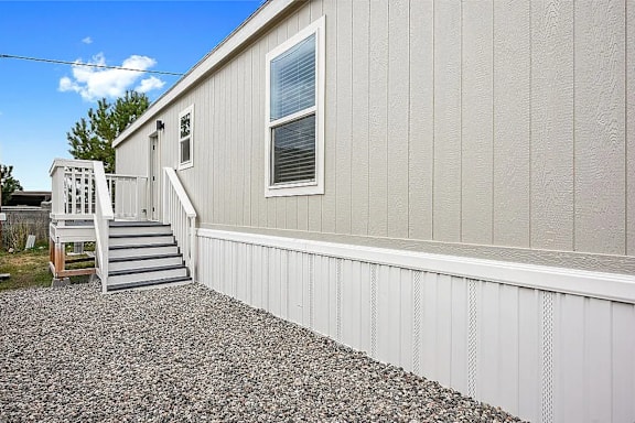 A house with a grey siding and a white door.