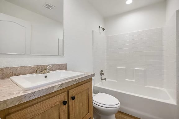 A white sink is on a marble countertop in a bathroom.