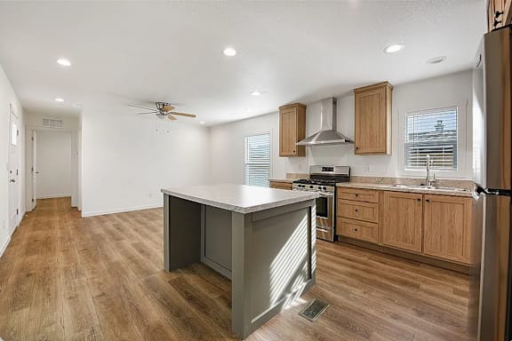 A kitchen with wooden floors and a white island.