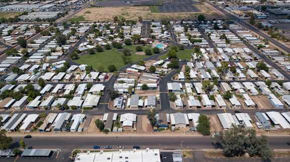A large, open field is surrounded by a grid of houses.