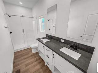 A bathroom with a sink, toilet and a walk in shower.