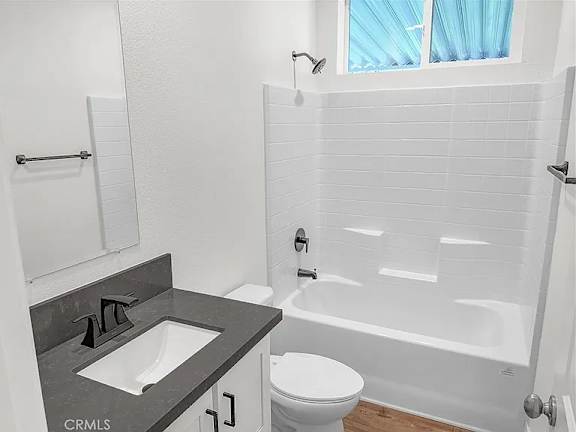 A white bathroom with a sink, toilet and bathtub.