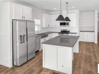 A kitchen with white cabinets and a black counter top.