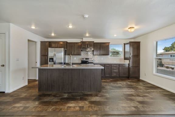 Extra large kitchen features an island, stainless steel appliances, plenty of storage, dishwasher, electric stove, garbage disposal, and oversize sink.
