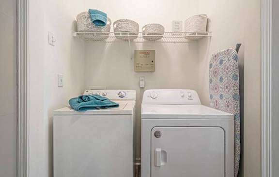 A white washing machine and dryer in a small laundry room.at The Atlantic Canton Ridge, Canton