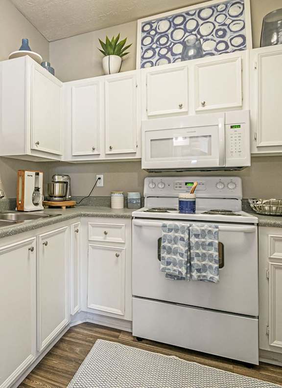 A white kitchen with a white oven and white cabinets.at The Atlantic Canton Ridge, Georgia