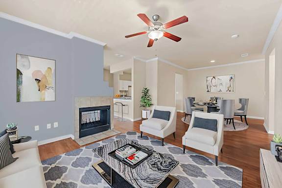 A living room with a fireplace and a ceiling fan at Reserve at Canyon Creek,San Antonio,TX
