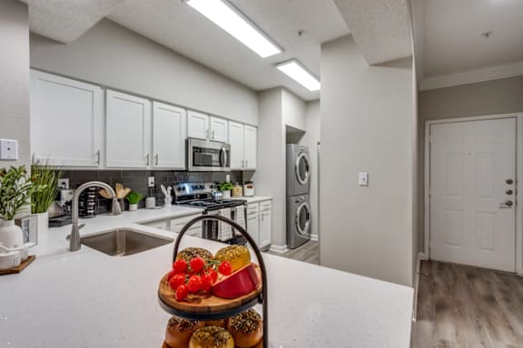 A kitchen with a white countertop and a basket of fruit on it. at Montecito Apartments, Houston, Texas