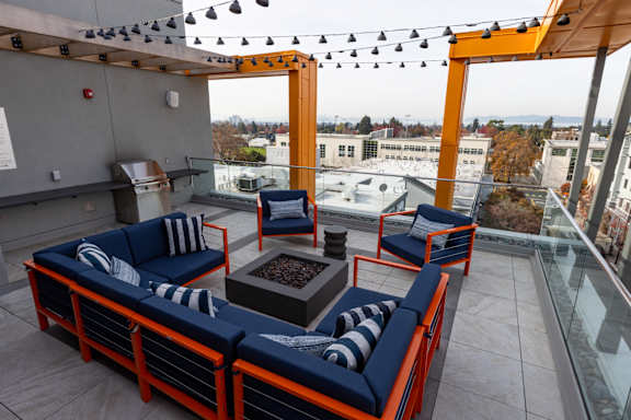 A rooftop patio with orange and blue furniture.