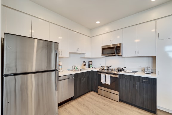 a modern kitchen with stainless steel appliances and white cabinets