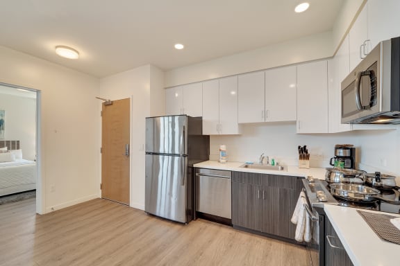 a renovated kitchen with stainless steel appliances and white cabinets