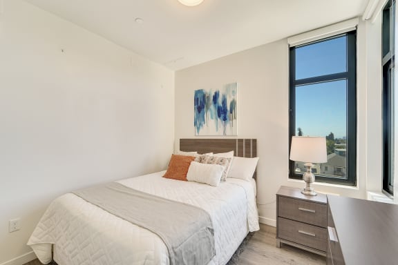 a bedroom with a bed and a large window