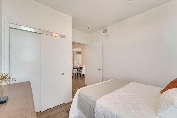 a bedroom with a large white bed and a closet