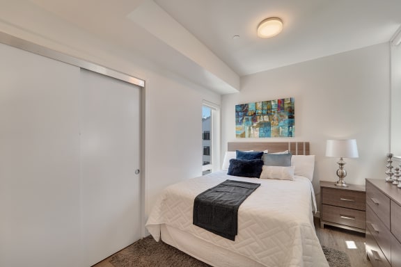 a white bedroom with a large bed and a closet