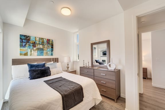 a bedroom with a bed and a dresser with a mirror