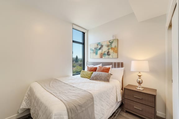 a bedroom with a bed and a large window
