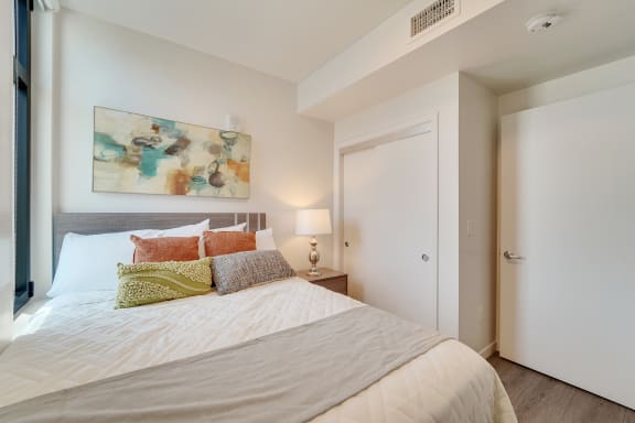 a bedroom with a large bed and a painting on the wall