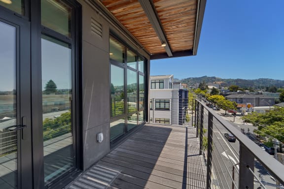 a balcony with a view of a city and a glass door