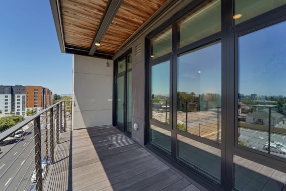 a balcony with glass doors and a city view
