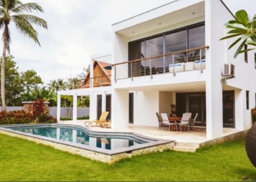 a white house with a pool in the yard