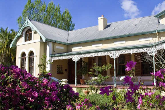 a house with a porch and flowers in front of it