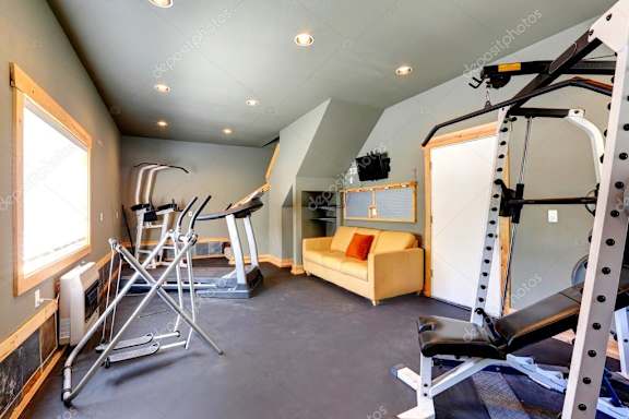 interior of a modern gym with equipment and a couch stock photo #
