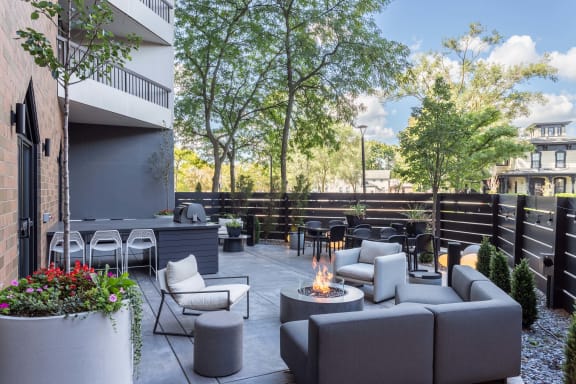 an outdoor patio with couches and chairs and a fire pit