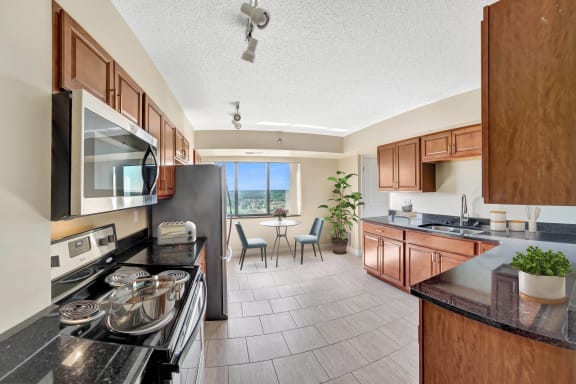 the view of a kitchen and dining room with wood cabinets