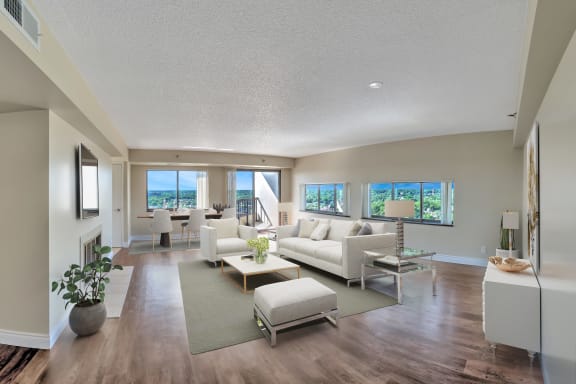 a living room with white couches and chairs and a rug