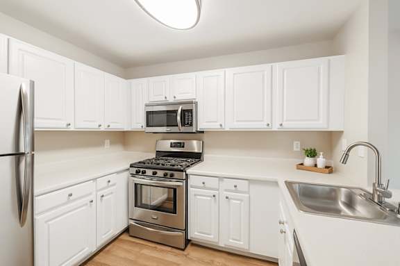 A kitchen with white cabinets and stainless steel appliances.