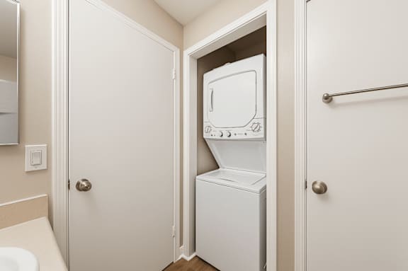 A white dryer is in a small closet.