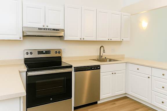 A kitchen with white cabinets and a black oven.