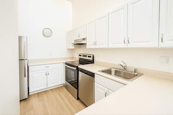 A kitchen with white cabinets and appliances.