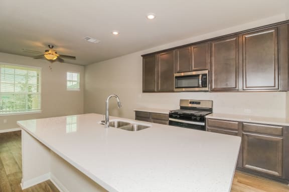 a kitchen with a large white island with a sink and a stove