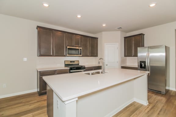 a kitchen with a large island and stainless steel appliances