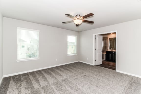 an empty bedroom with a ceiling fan