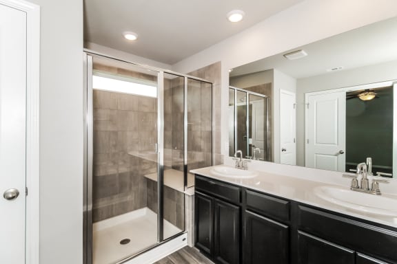 a bathroom with a large mirror and a walk in shower