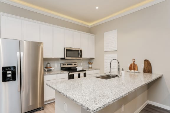 a kitchen with a granite counter top and a stainless steel refrigerator