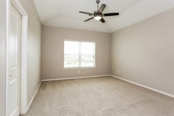 A room with a ceiling fan and a window.
