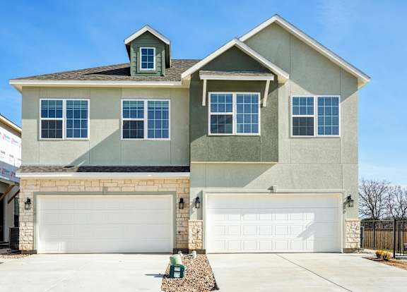 A two-story house with a garage on the ground floor.