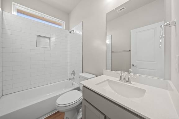 A white bathroom with a toilet, sink, and bathtub.