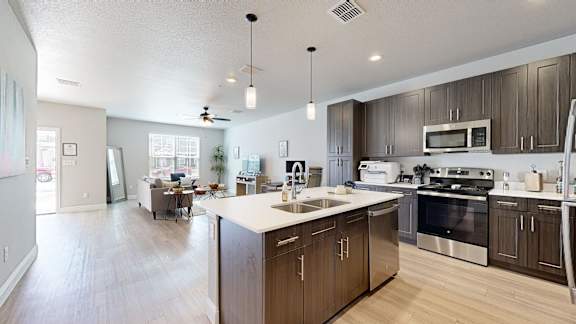 A modern kitchen with wooden cabinets and stainless steel appliances.