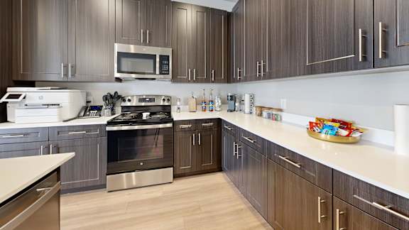 A modern kitchen with dark wood cabinets and stainless steel appliances.