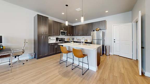 A kitchen with a white counter and brown cabinets.